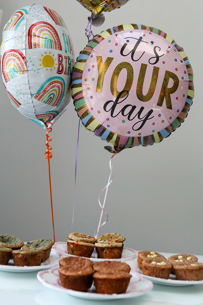 Balloons and muffins on a table.